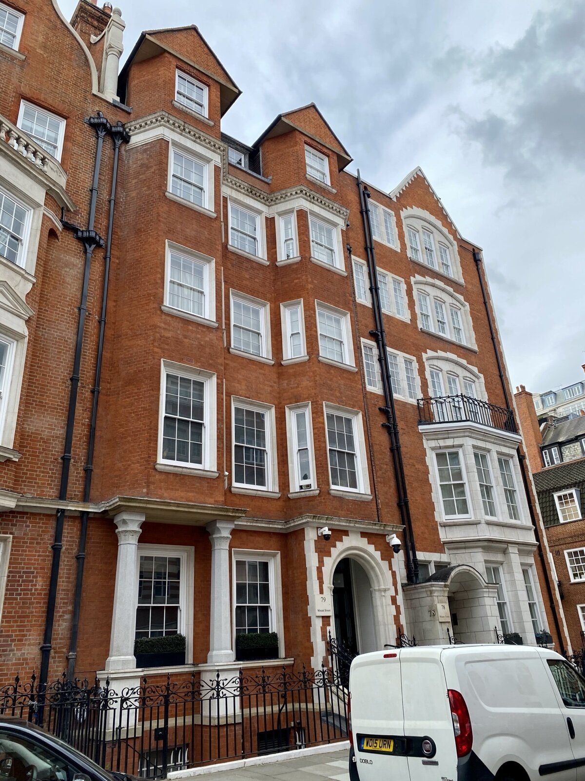 The red brick and Portland stone frontages of 78 and 79 Mount Street in Mayfair, with iron railings at pavement level