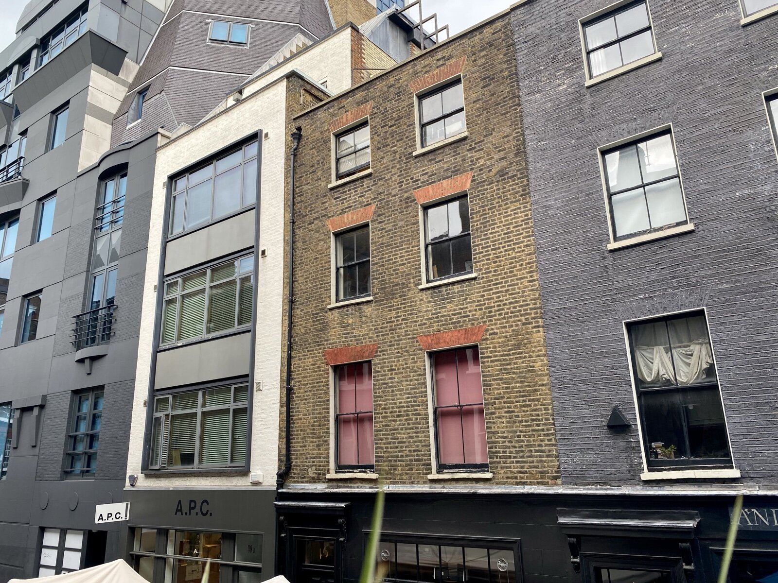 Brick Georgian terraced houses above shopfronts on Lexington Street, Soho