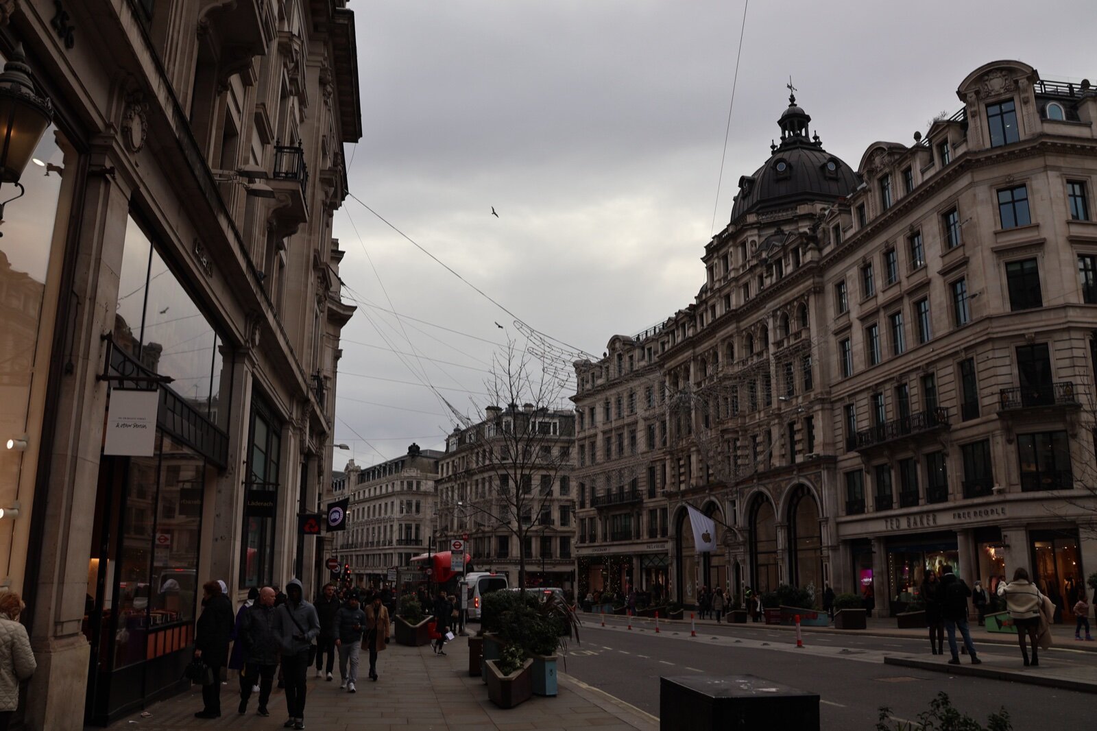 Shoppers on Regent Street in W1 with Christmas light frames strung above the road