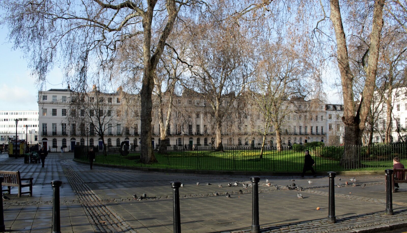 The Georgian terraces of Fitzroy Square in London, seen across the paved pedestrian area and the railed garden in winter