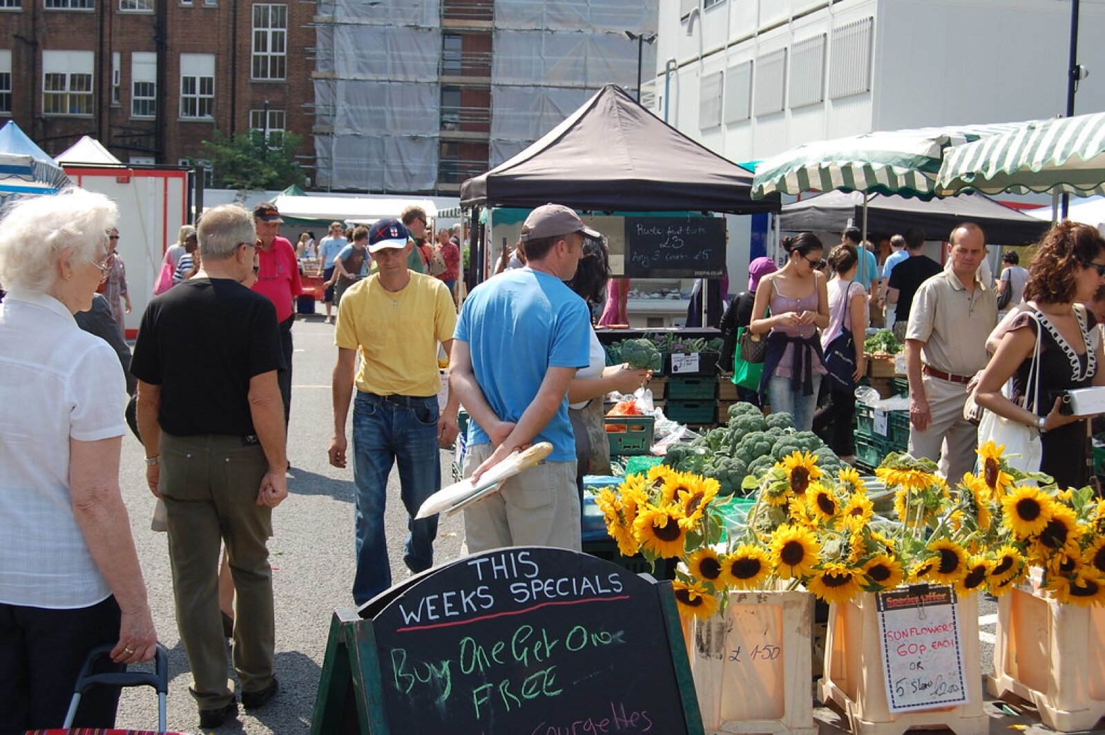 Shoppers at a flower and vegetable stall at Marylebone Farmers' Market